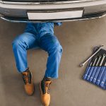 Auto mechanic checking car