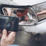 Insurance agent working during on site car accident claim process - people and car insurance claim concept